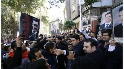 Syrians supporting and opposing Bashar al Assad clash near the Syrian embassy in Cairo on Tuesday.