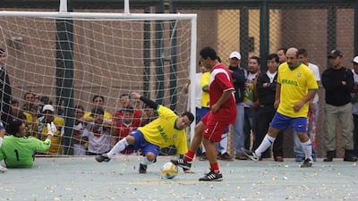 Prisoners, wearing jerseys in the colours of Brazil's national football team, play against a team of veteran Peruvian players, who are visitors to the Castro-Castro prison in Lima for the Prison World Cup event ahead of the 2014 World Cup in Brazil. Mariana Bazo / Reuters / June 2, 2014