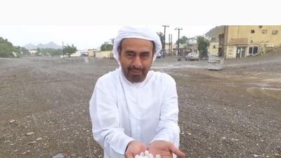 A man wearing national dress holds a pile of hail stones on the Masafi to Dibba road, according to the Storm Centre Twitter account. Courtesy: Storm Centre