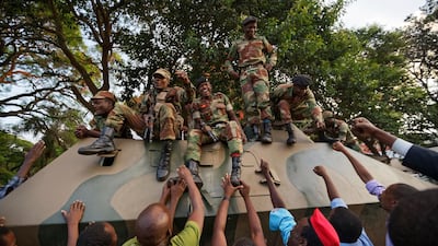Zimbabweans reach thank army soldiers, as they celebrate outside the parliament building immediately after hearing the news that President Robert Mugabe had resigned, in downtown Harare, Zimbabwe. Ben Curtis / AP Photo