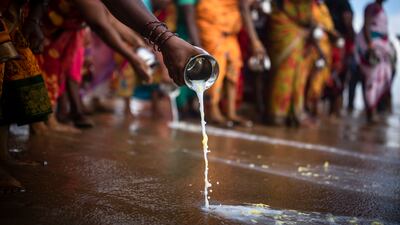 People pour milk in the waters of the Bay of Bengal as they honour the victims of the 2004 Indian Ocean tsunami disaster, in Chennai, India. EPA