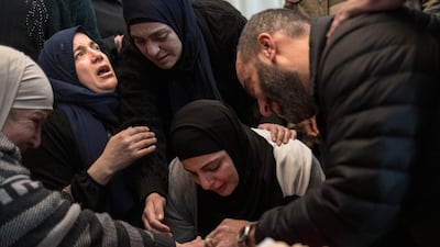 The family of Tawfic Abdel Jabbar mourn at his funeral. The teenager had travelled with his parents from the US to the West Bank to visit their hometown. AFP