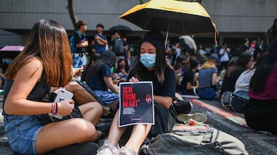 A student displays a poster referring to the recent police shooting of an 18-year-old student on October 1. AFP