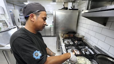 Chef Marcelo Perez Jr cooks up a meal at Cycle Hub, which already discloses the calorie content of every food item to customers. Chris Whiteoak / The National