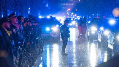 Firefighters and police officers stand outside the Cook County Medical Examiner's Office, in Chicago, US, as a procession carrying the body of an officer shot dead on duty passes. AP