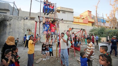 Iraqi children play on a swing in Mosul, Iraq. Reuters