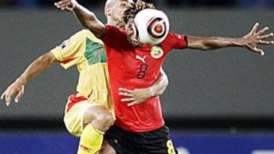 Goncalves Fumo of Mozambique, right, is challenged by Romuald Boco during their game at the Ombaka stadium in Benguela.