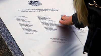 A relative of an Australian victim of Malaysia Airlines jet MH17 touches a memorial that was unveiled outside Parliament House in Canberra, Australia, July 17, 2015. Reuters / David Gray