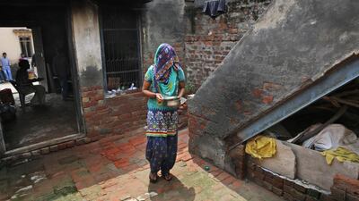Anita Berwal, originally from the Indian southern state of Kerala, carries food for her father-in-law at their home, in Sorkhi village.