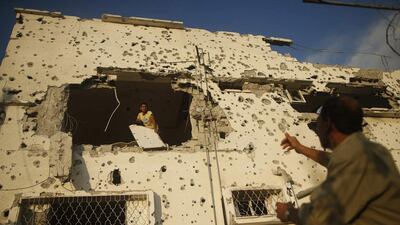 A Palestinian man removes belongings from his house that witnesses said was damaged during the seven-week Israeli offensive, in the east of Gaza City. Mohammed Salem / Reuters