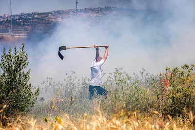 A man tries to extinguish a fire after a reported arson attack by Israeli settlers in Huwara in the occupied West Bank. AFP