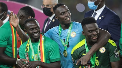 Edouard Mendy, centre, celebrates Senegal's Africa Cup of Nations triumph with Sadio Mane and Bamba Dieng. AFP