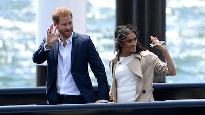 Prince Harry and Meghan wave as they arrive at the Opera House in Sydney. AP Photo