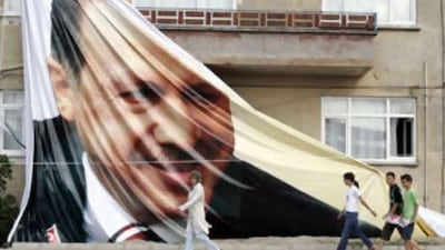 People walk in front of a giant poster of the Turkish prime minister Recep Tayyip Erdogan, in Sakarya, Turkey.