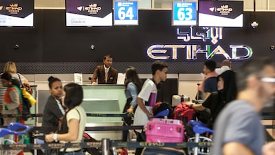 Passengers checking in for flights at the Abu Dhabi International Airport. Antonie Robertson / The National