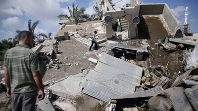 Palestinian men inspect their destroyed house following an Israeli air strike in Gaza City on July 15. AFP Photo