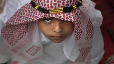 A Nepalese Muslim boy reacts to the camera as he waits to offer prayers on Eid Al Fitr at a mosque in Kathmandu, Nepal, Saturday, July 18, 2015. Millions of Muslims across the world are celebrating the Eid Al Fitr holiday, which marks the end of the month-long fast of Ramadan. Niranjan Shrestha / AP photo