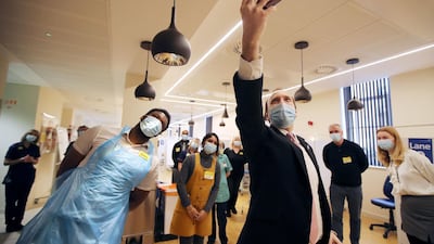 Britain's Health Secretary Matt Hancock takes a selfie with staff at the vaccination centre at Queen Elizabeth Hospital, Birmingham. AFP