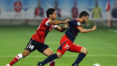 Tariq Ahmed of Al Ahli chases Al Shabb's Hassan Maatouk for the ball. Satish Kumar / The National