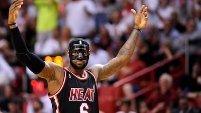 epa04103271 Miami Heat forward LeBron James encourages the crowd during their NBA basketball game against the New York Knicks at the American Airlines Arena in Miami, Florida, USA, 27 February 2014. James broke his nose in a previous game against the Oklahoma City Thunder and is wearing the mask for protection. EPA/RHONA WISE CORBIS OUT