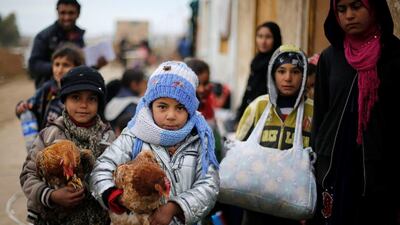 Displaced children who fled the ISIL stronghold of the Arabi neighbourhood, north of Mosul with their families carry their chickens as they wait to register their names at a military checkpoint before being transported to the camps in the east of Mosul, Iraq on January 25, 2017. Muhammad Hamed/Reuters