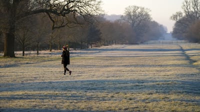 A person walks over frosted grass in Windsor Great Park, Berkshire. The Met Office said the West Midlands, East Midlands, East, South East and South West are also set to experience colder temperatures through Sunday. PA