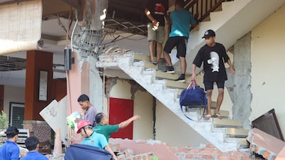 People flee a damaged building in Labuan Bajo, East Nusa Tenggara. Reuters