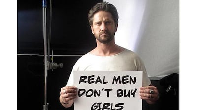 Gerard Butler holds up a sign reading Read Men Don’t Buy Girls in support of the movement. Courtesy Gerard Butler