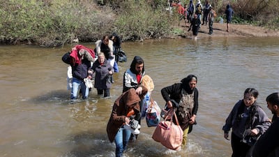 Alawite Syrians, who fled the violence in western Syria, walk in the water of the Nahr El Kabir River, after the reported mass killings of Alawite minority members, in Akkar, Lebanon. Reuters