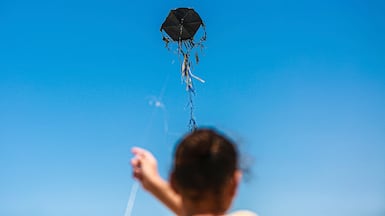 A Palestinian child flies a kite in a displacement camp in Gaza City on July 29. Middle East Images via AFP