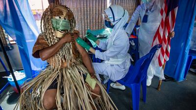 An indigenous man of the Mahmeri tribe receives a dose of vaccine in Banting, near Kuala Lumpur, Malaysia.