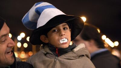 A child shows his support for Uruguay player Luis Suarez, by wearing toy plastic vampire’s teeth, as he awaits the arrival of Suarez at Carrasco International Airport in the outskirts of Montevideo, Uruguay, Thursday, June 26, 2014. The Uruguay forward, widely regarded as one of the best players in the world, was banned by FIFA from all football for four months on Thursday for biting an Italian opponent in an incident that marred the team’s victory and progression to the second round. AP Photo/Matilde Campodonico