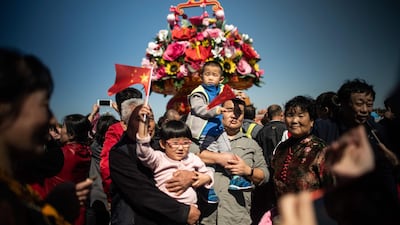 People pose for a picture as they visit Tiananmen Square during National Day in Beijing. Fred Dufour/AFP