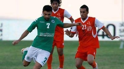 Ajman, United Arab Emirates, Nov 18 2011, Ajman v Al shabab- (lright orange kit) Ajman's #23 Abdulaziz Ismail attempts to block (left green kit) Al Shabab's #7 Haydarov Azizbek at Rashid bin Zayed Stadium Nov. 18 2011. Mike Young / The National