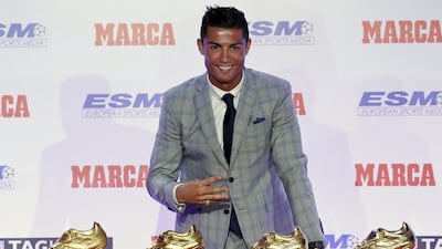 Real Madrid striker Cristiano Ronaldo poses in front of his four Golden Boot trophies during a ceremony in Madrid, Spain, October 13, 2015. REUTERS/Andrea Comas
