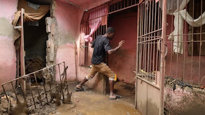 A man steps over mud outside a house after heavy rains brought by Hurricane Melissa caused deadly flooding, in Petit Goave, Haiti October 31, 2025. REUTERS / Egeder Pq Fildor