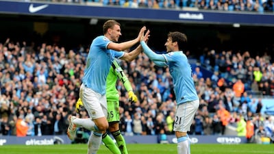 Edin Dzeko of Manchester City is congratulated by teammate David Silva after scoring his team's third goal past goalkeeper Paulo Gazzaniga of Southampton during the Premier League match between Manchester City and Southampton at Etihad Stadium on April 5, 2014 in Manchester, England. Chris Brunskill / Getty Images