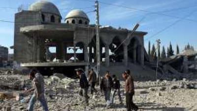 Palestinians walk past a destroyed mosque in Beit Hanoun, northern Gaza Strip.
