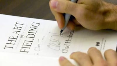Chad Harbach signs a copy of his debut novel The Art of Fielding. Mark Hertzberg / AP Photo via Journal Times