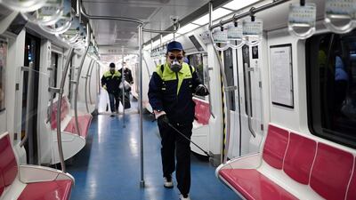 A staff member sprays disinfectant in a subway train compartment in Beijing. AFP