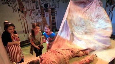 School children react seeing a dummy mummy at the Abu Dhabi Science Festival yesterday at the Abu Dhabi National Exhibition Centre.