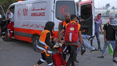 Paramedics carry a man towards an ambulance amidst clashes between Palestinian protesters and Israeli forces following a protest to denounce the annual nationalist "flag march" through Jerusalem, near the Beit El settlement at the northern entrance to the city of Ramallah in the occupied West Bank on May 29, 2022. AFP