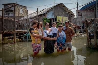 Emily Juliano outside her home on stilts with her children Charlenelyza, Leemark and Lexies, and her grandchildren Rebecca Nicole and Athena Tazzana. Getty Images
