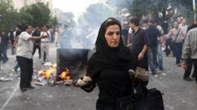 An Iranian woman carries rocks at an anti-government protest in Tehran In a photo posted in the internet. Many protesters have reportedly been arrested or beaten.