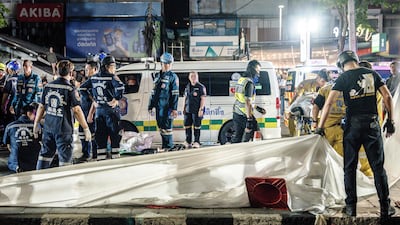 Emergency workers prepare to place the bodies of victims into ambulances after a fire at the Rong Beer Na Lat Phrao bar in Bangkok on July 13. AFP