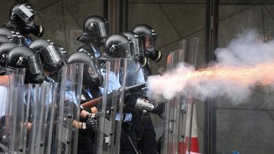 Police officers fire tear gas at protesters. Reuters