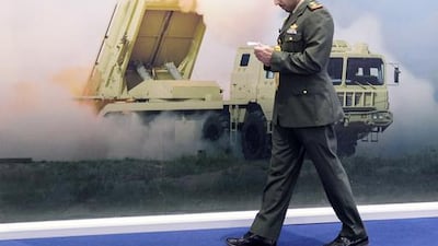 Above, a delegate walks along a missile system billboard at Idex 2017. Reem Mohammed / The National