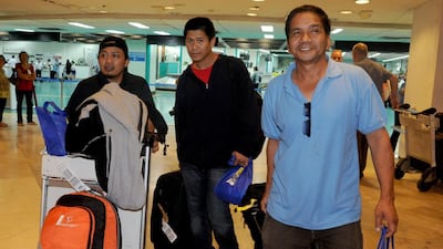 Some of the 41 Filipino workers arrive at Ninoy Aquino International airport in Manila on Monday as they flew home from strife-torn Libya at the government's expense. More than 11,000 Filipinos in Libya have ignored appeals to evacuate, with many apparently choosing to take their chances in the war-torn country rather than risk unemployment at home, a foreign department spokesman said. Jay Directo / AFP