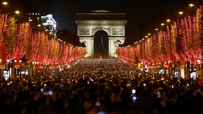 People attend New Year celebrations on the Champs-Elysees avenue as the traditional light show and fireworks have been cancelled due to the spread of the coronavirus disease (COVID-19) in Paris, France.