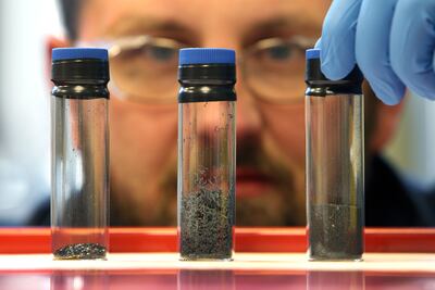 Scientist examines the progression of graphene in three vials. Getty